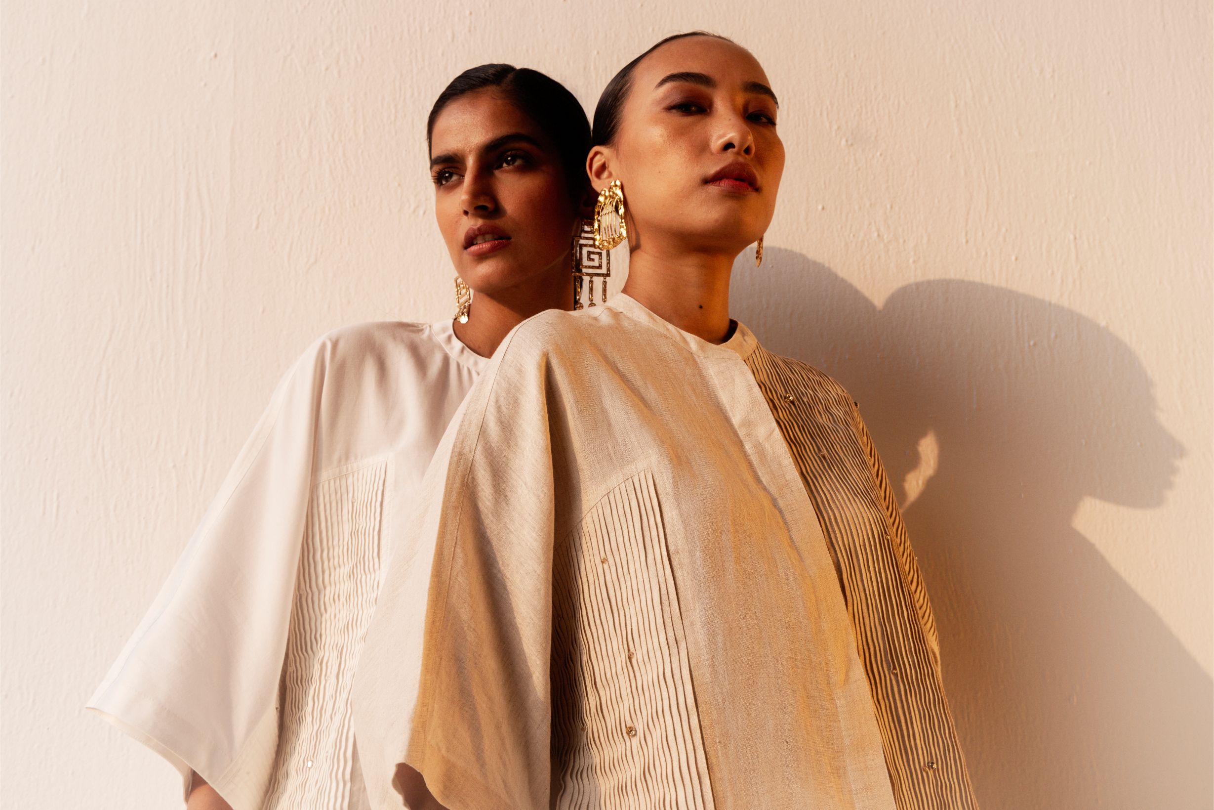 Elegant white cotton satin shirt with a Mandarin collar, kimono-style pleated sleeves, and subtle crystal embellishments, handcrafted in India
