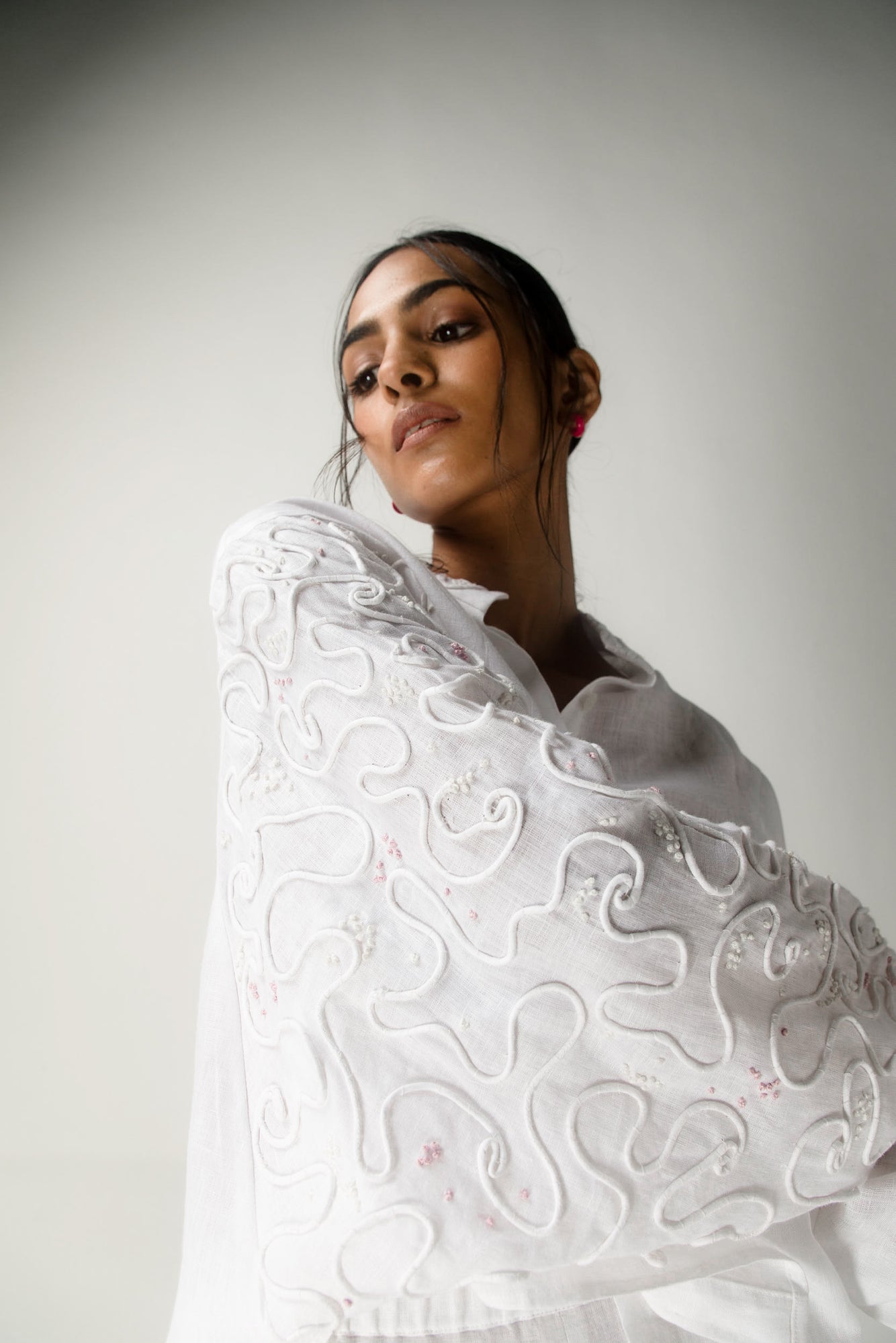 White Italian linen top with dolman sleeves, featuring intricate dori handwork; a luxurious, artisan-crafted womenswear piece