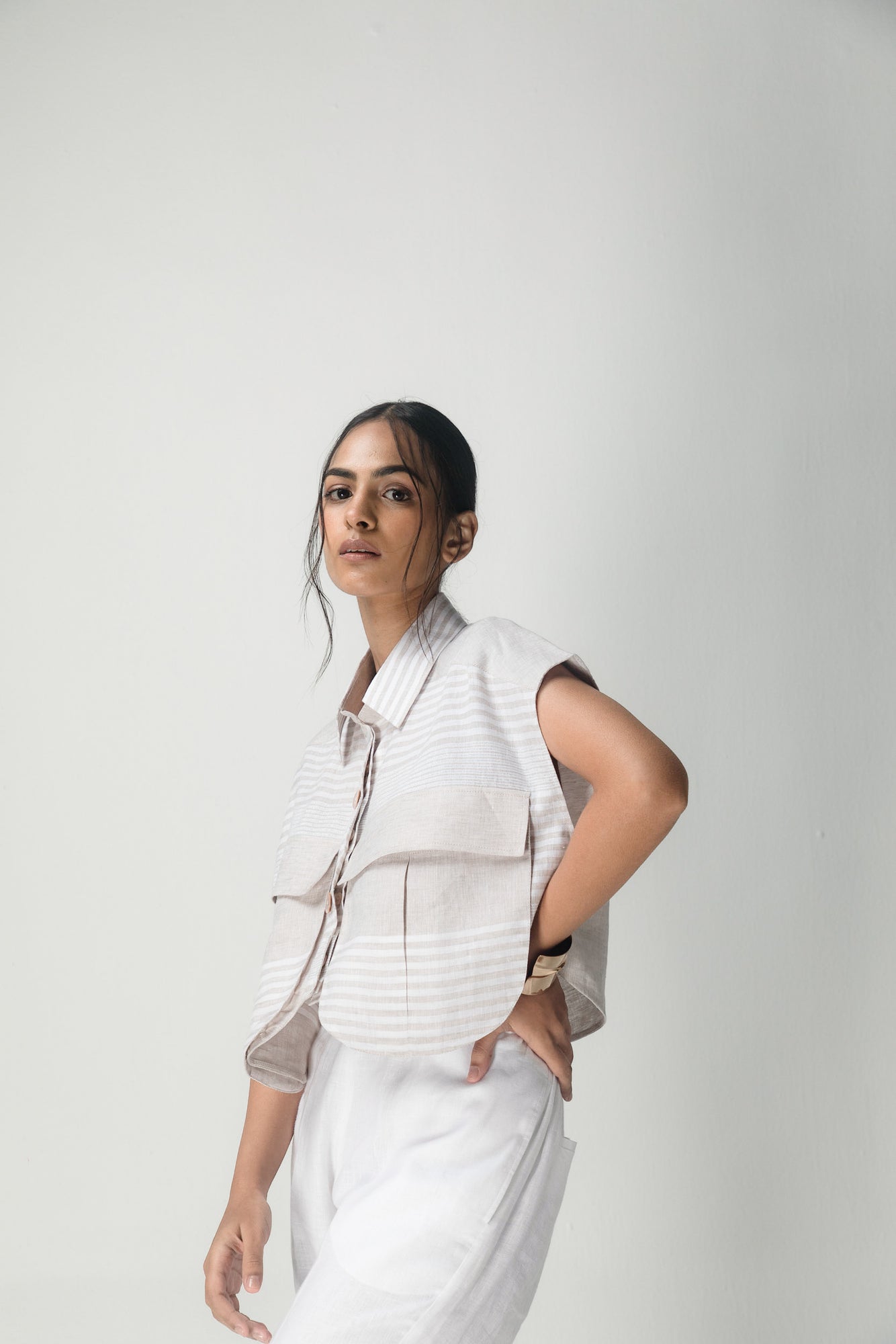 Luxurious linen crop shirt with artisan-crafted cargo pockets, featuring a chic white and beige stripe pattern, tailored for premium womenswear