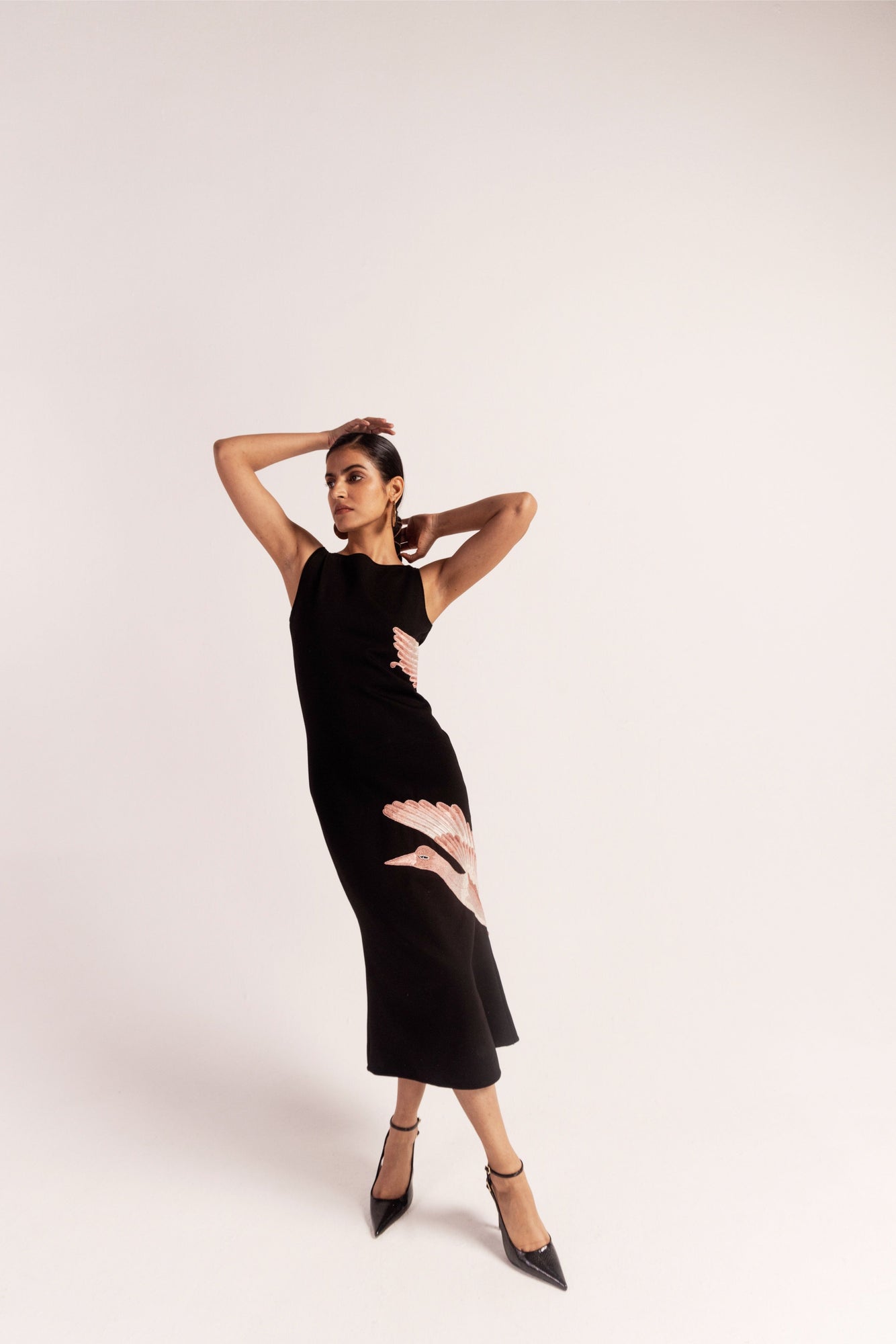Luxurious black hosiery dress with hand-embroidered silk crane, sleeveless, knee-length, round ribbed neckline; artisan-made elegance