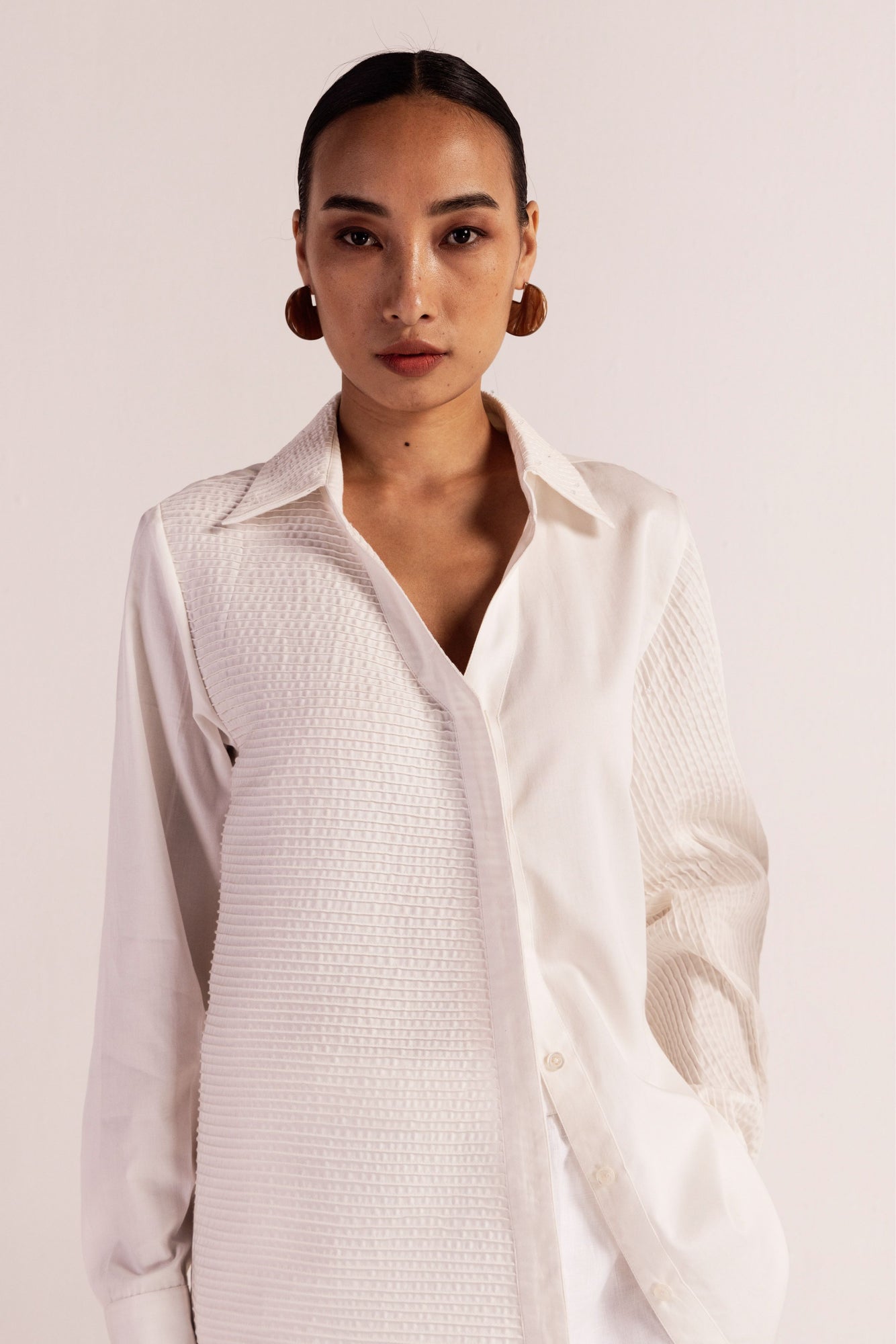 Luxurious white cotton satin shirt with asymmetrical pintucks, adorned with Japanese glass crystals, full sleeves, and classic collar