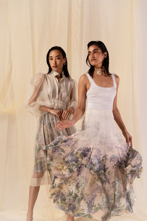 Luxurious mid-length dress in buttery moss, featuring a sheer organza overlay, ruffled neckline, and balloon sleeves for an elegant silhouette