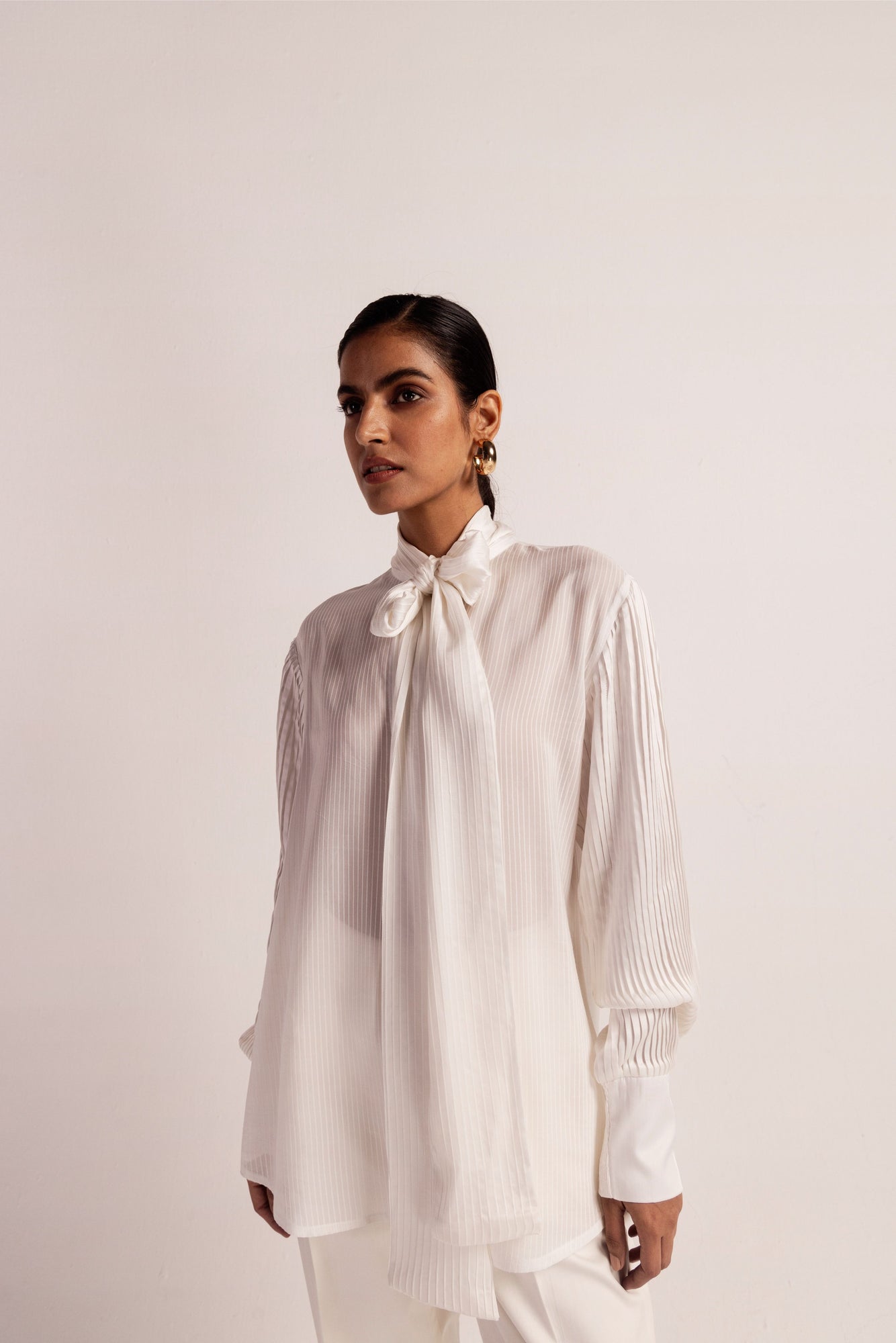 Luxurious orange stripe shirt with Bemberg satin sleeves, scarf-like front, and intricate pin tucks; handcrafted elegance in womenswear
