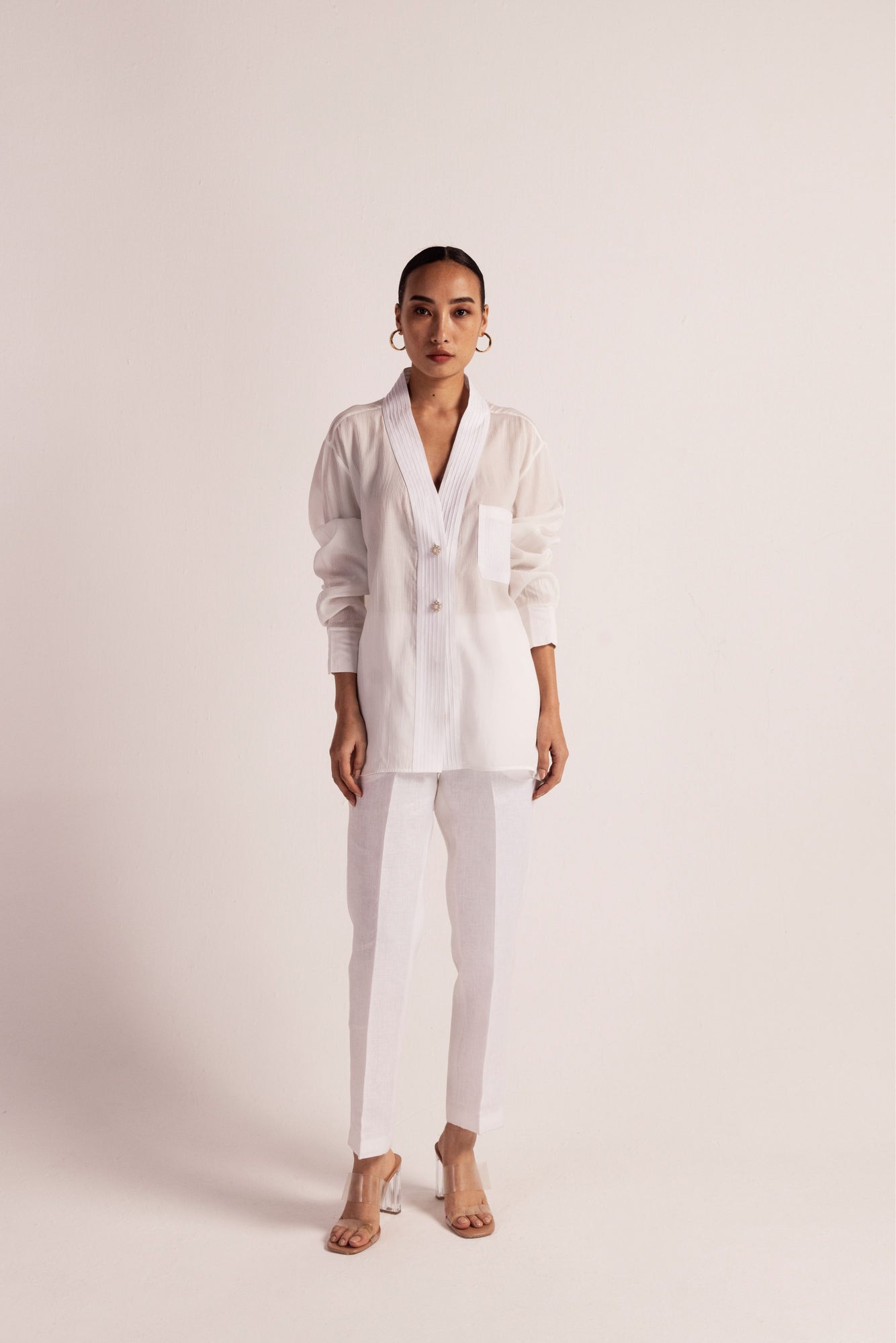 Luxurious orange peel and linen shirt with pin-tuck details, shawl collar, pearl buttons, and full sleeves, showcasing artisan craftsmanship