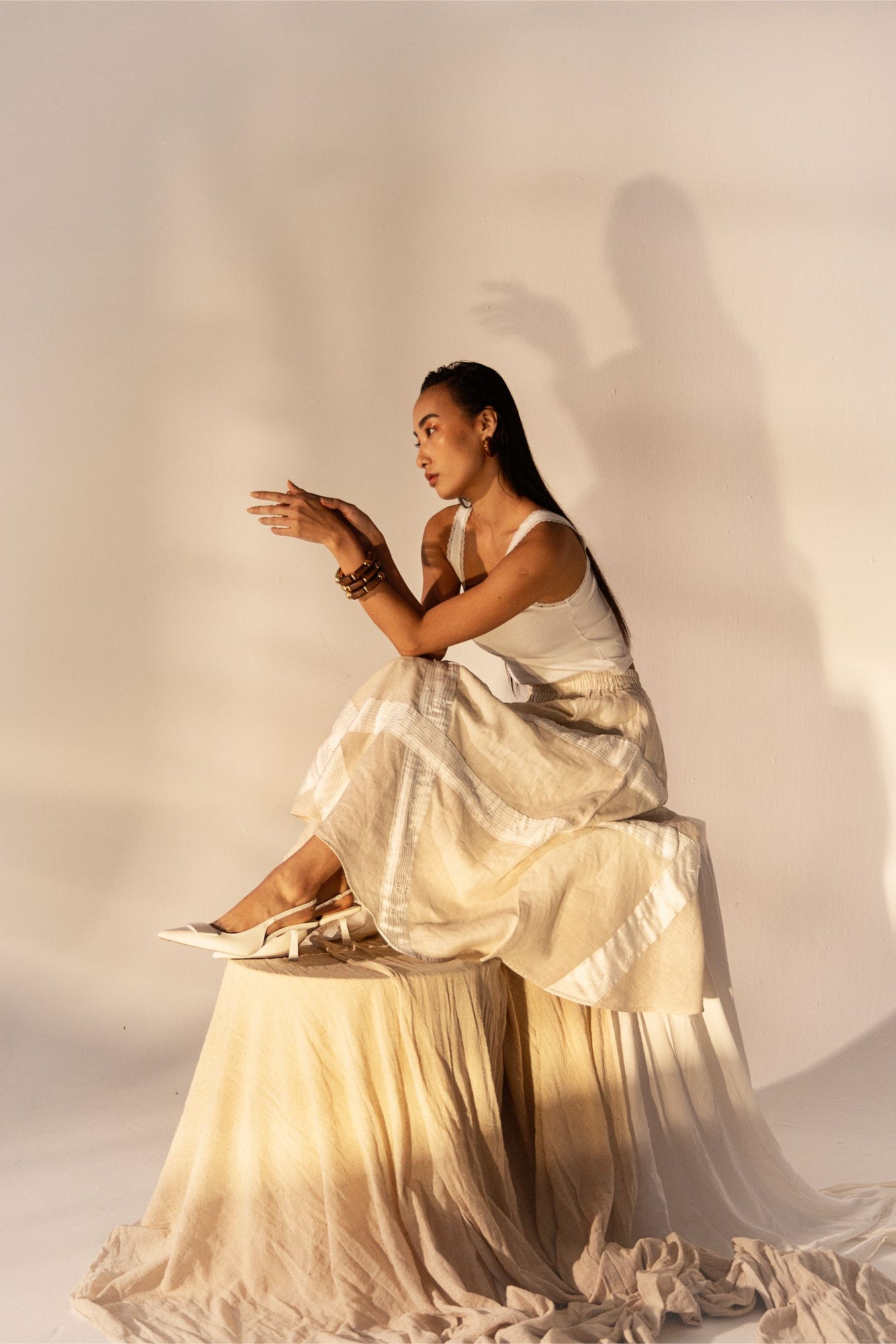 Almond beige flowing skirt with diagonal pleats and crystal accents, crafted from premium linen and satin, showcasing luxury and elegance
