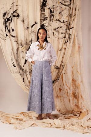 Powder blue wide-leg linen pants with an elasticated waist, side pockets, and flared design, showcasing luxury and artisan craftsmanship