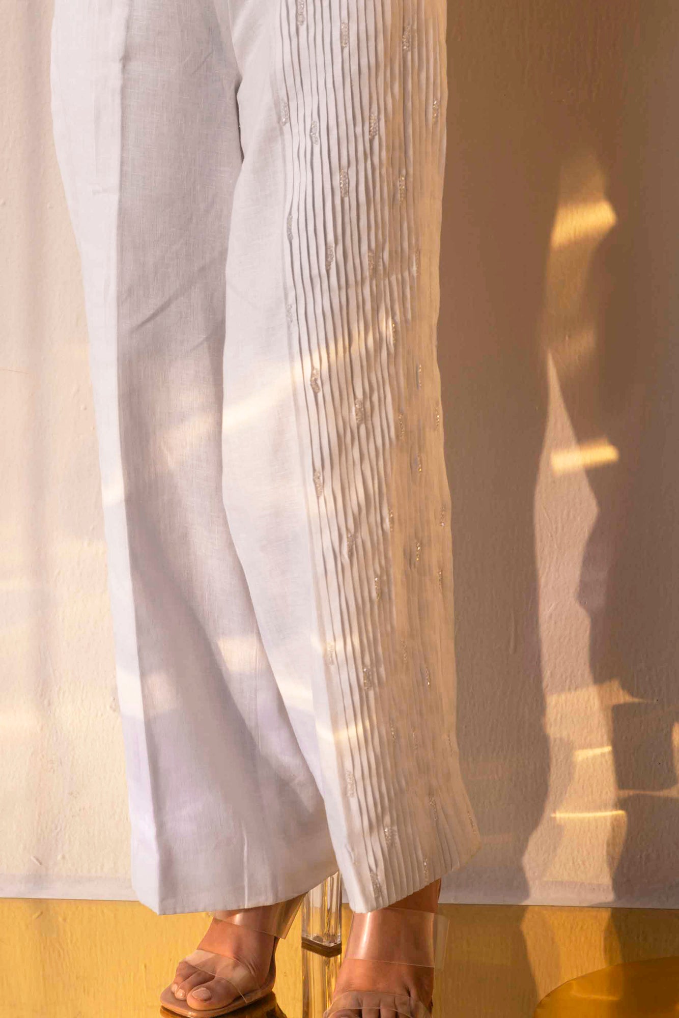 Handcrafted alabaster trousers with elegant crystal pleats, showcasing luxury womenswear in premium handloom fabric by NJ3 Atelier