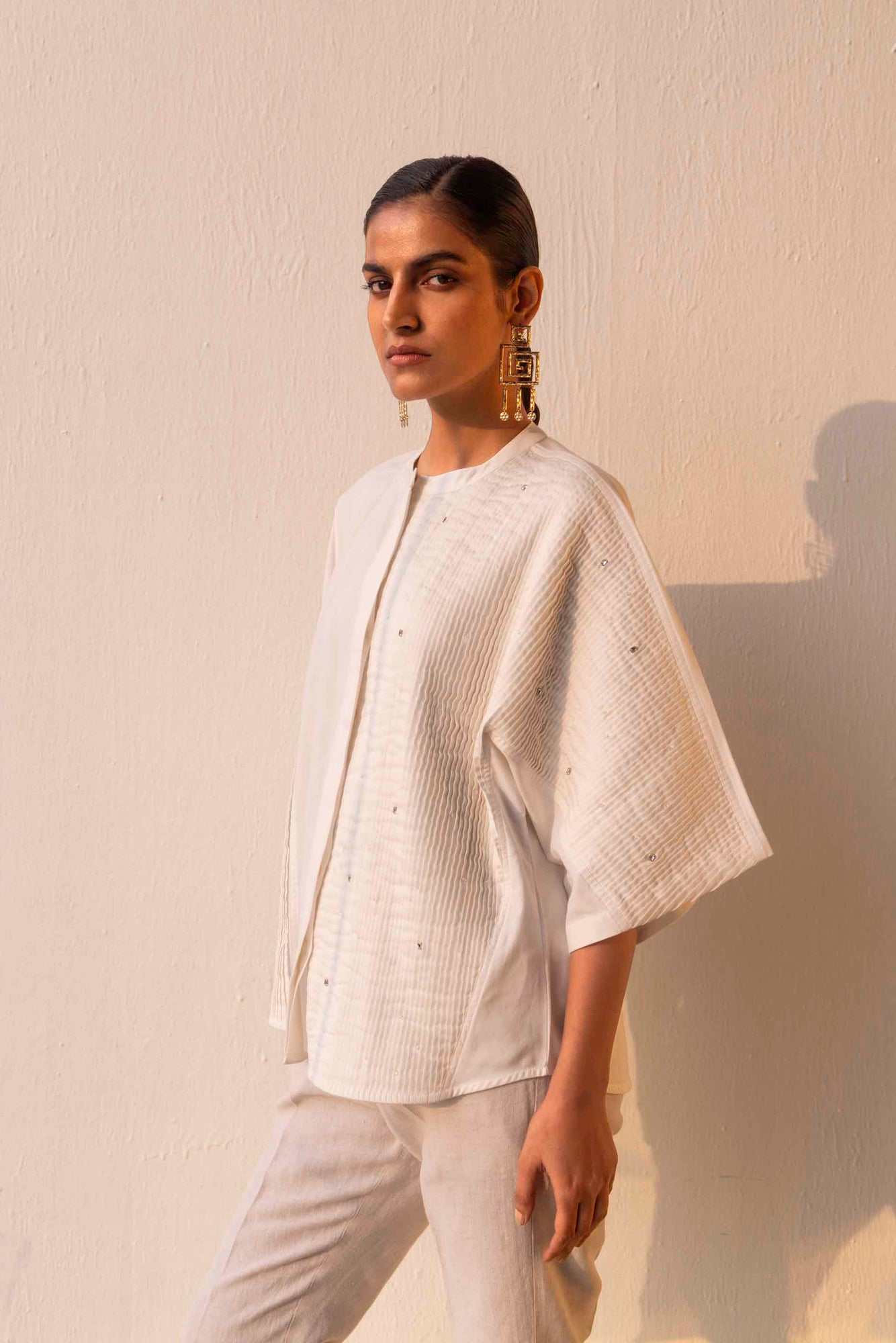 Elegant white pleated shirt in premium handloom fabric, showcasing a refined silhouette, epitomizing luxury womenswear craftsmanship