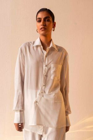 Luxurious orange shirt with a classic collar, pearl buttons, asymmetrical hem, full sleeves, and structured cuffs; artisan-made elegance