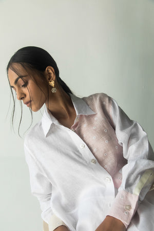 Exquisite handcrafted white shirt with artisan floral patterns, premium fabric, and elegant silhouette, epitomizing luxury womenswear
