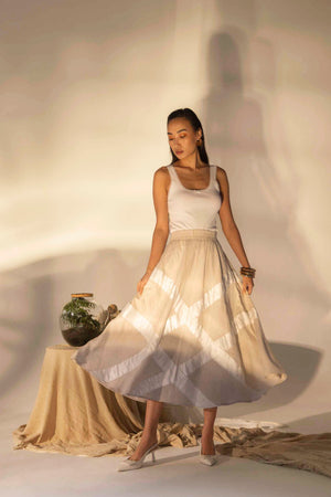 Elegant almond beige skirt in premium handloom fabric, showcasing a refined tuck design, epitomizing luxury womenswear craftsmanship