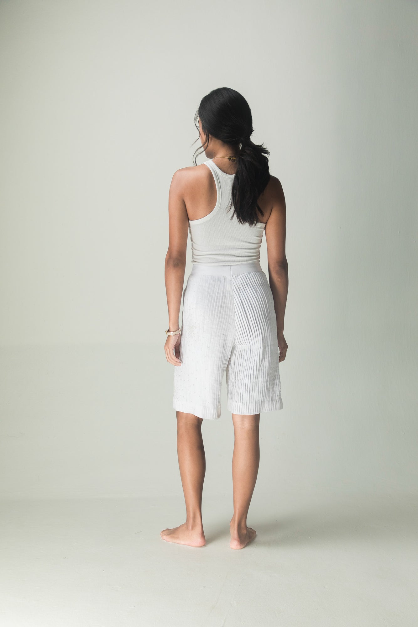 Luxurious handloom pleat shorts in rich navy, showcasing artisan craftsmanship and premium fabric for an elegant, timeless silhouette