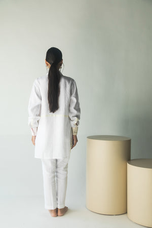 Handcrafted white shirt with artisan floral patterns, showcasing premium handloom fabric and luxury womenswear elegance