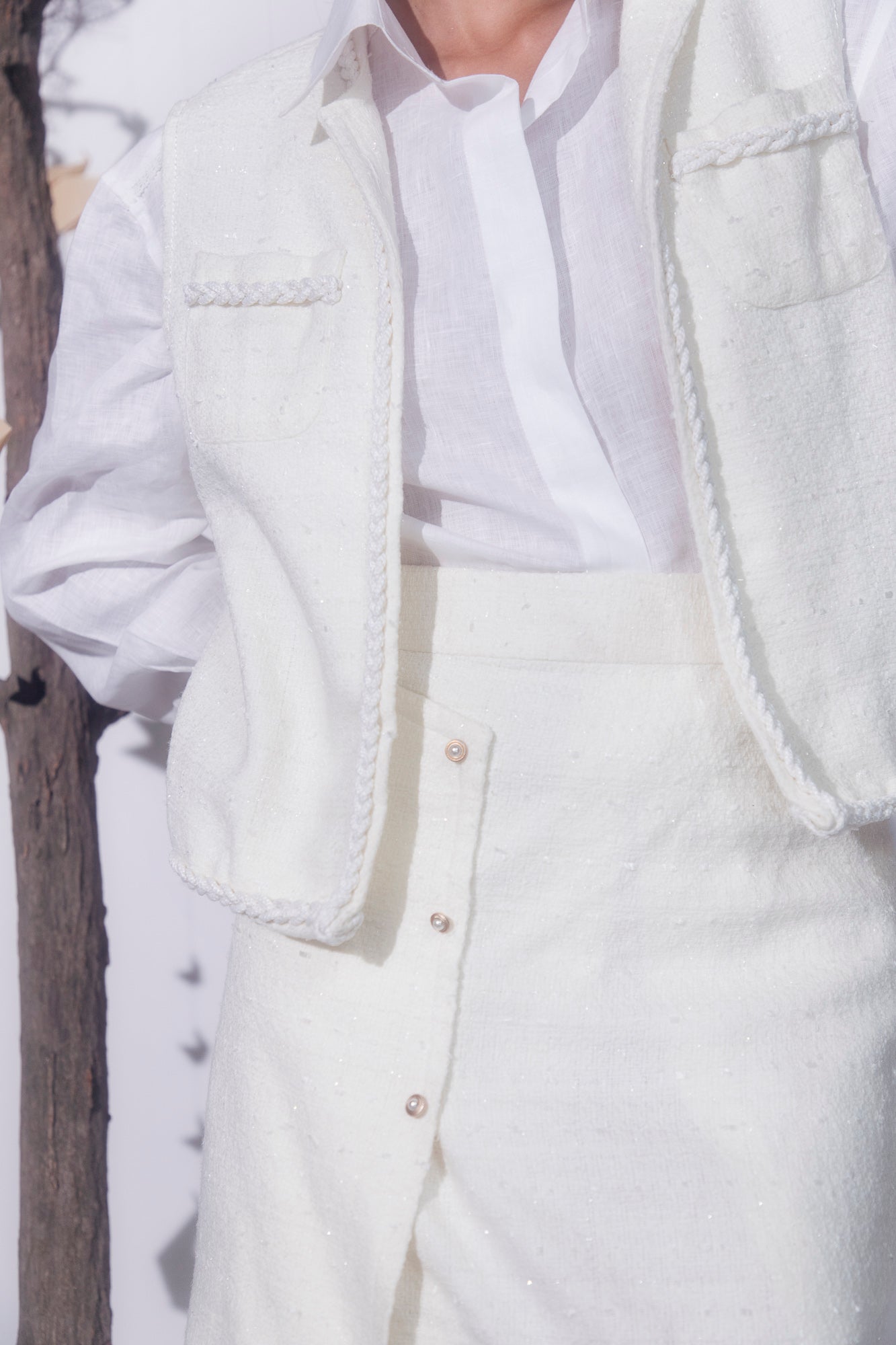 Pearl-white handcrafted jacket in premium fabric, showcasing luxury womenswear with elegant silhouette and artisan detailing