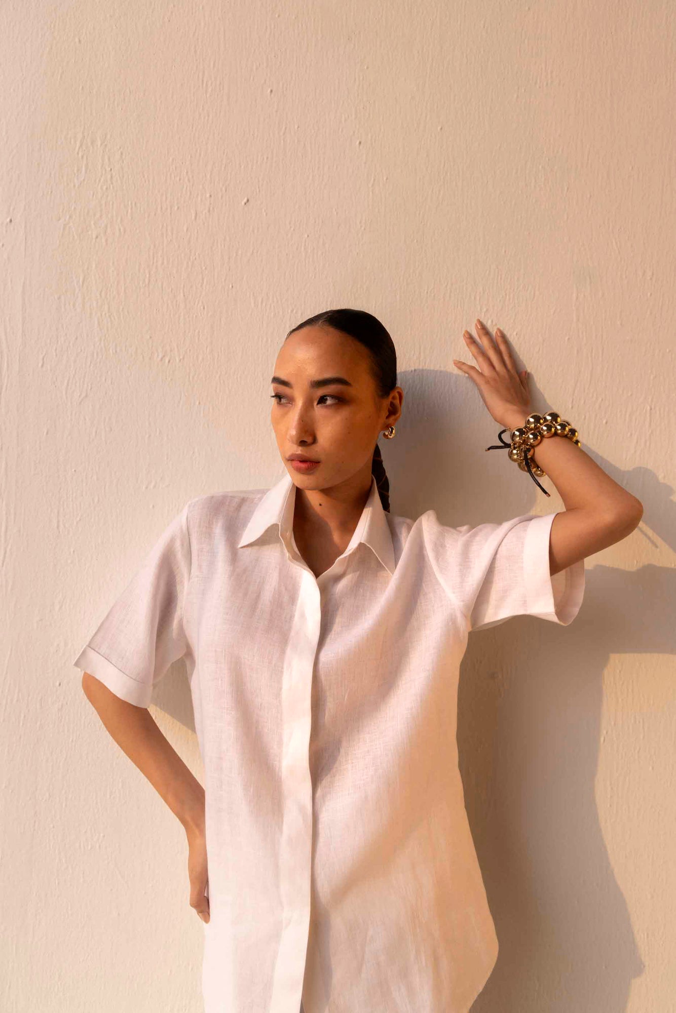 Rich gold linen shirt with classic collar, half sleeves, and intricate silk embroidery on the back, showcasing luxury artisan craftsmanship