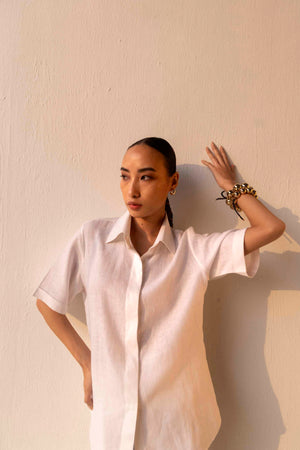 Rich gold linen shirt with classic collar, half sleeves, and intricate silk embroidery on the back, showcasing luxury artisan craftsmanship