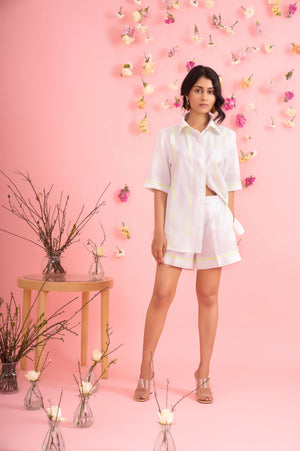 Luxury womenswear co-ord set in pure linen, featuring a white half pant and shirt with neon accents; artisan-crafted elegance