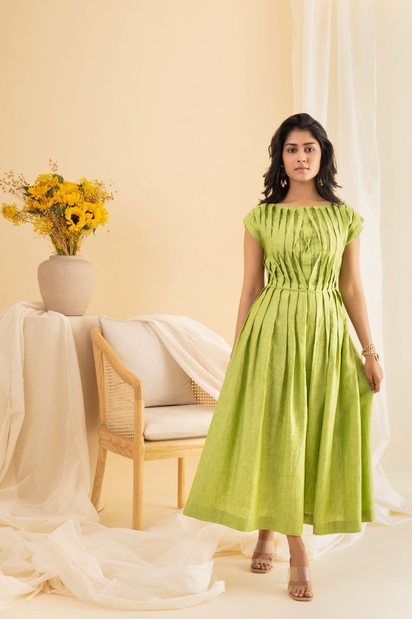 Elegant dragon-pleated dress in rich emerald, showcasing luxurious handloom fabric and exquisite artisan craftsmanship