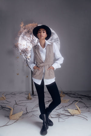 Sleeveless beige herringbone jacket with detachable belt, showcasing luxury womenswear craftsmanship; dry clean only