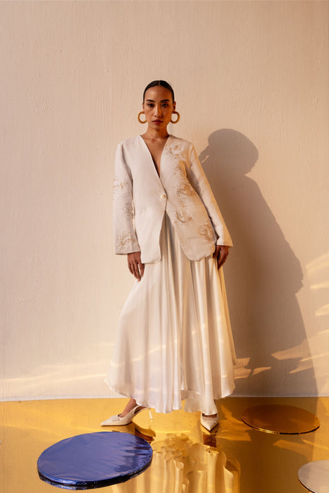 Velora Bead Blazer - White V-neck collarless blazer with hand-embroidered crystal bead detailing, worn with white skirt, front view - NJ3ATELIER luxury outerwear