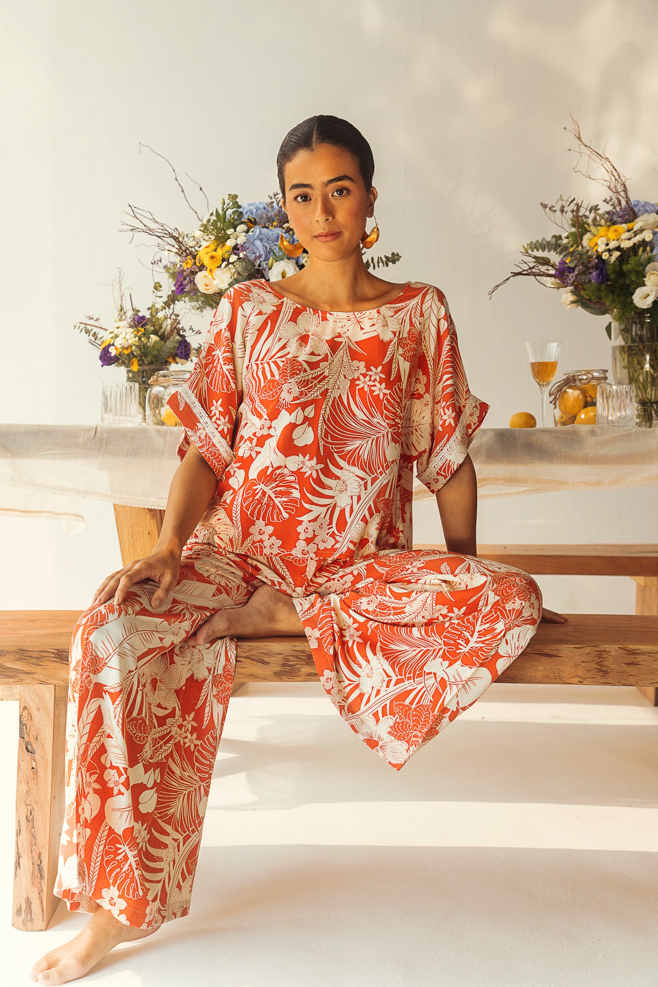 Luxurious wide-leg trousers in orange and white tropical print, crafted from premium organic viscose, showcasing artisan craftsmanship