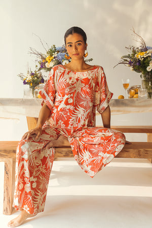 Luxurious wide-leg trousers in orange and white tropical print, crafted from premium organic viscose, showcasing artisan craftsmanship