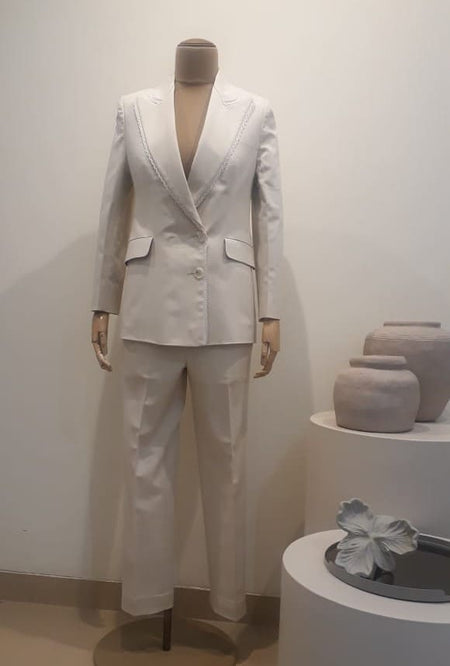 Beige denim Lycra suit with lace detailing and red lining, showcasing luxury womenswear craftsmanship; dry clean only